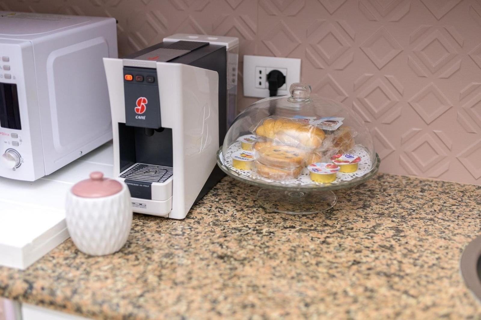 L'angolo cottura di Casa Deky con macchina del caffè, microonde e vassoio di paste per la colazione