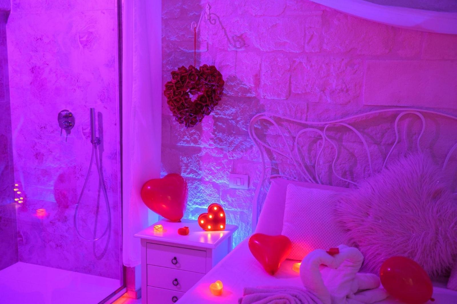 Il bagno allestito per un'occasione romantica, con cuori, candele e cromoterapia