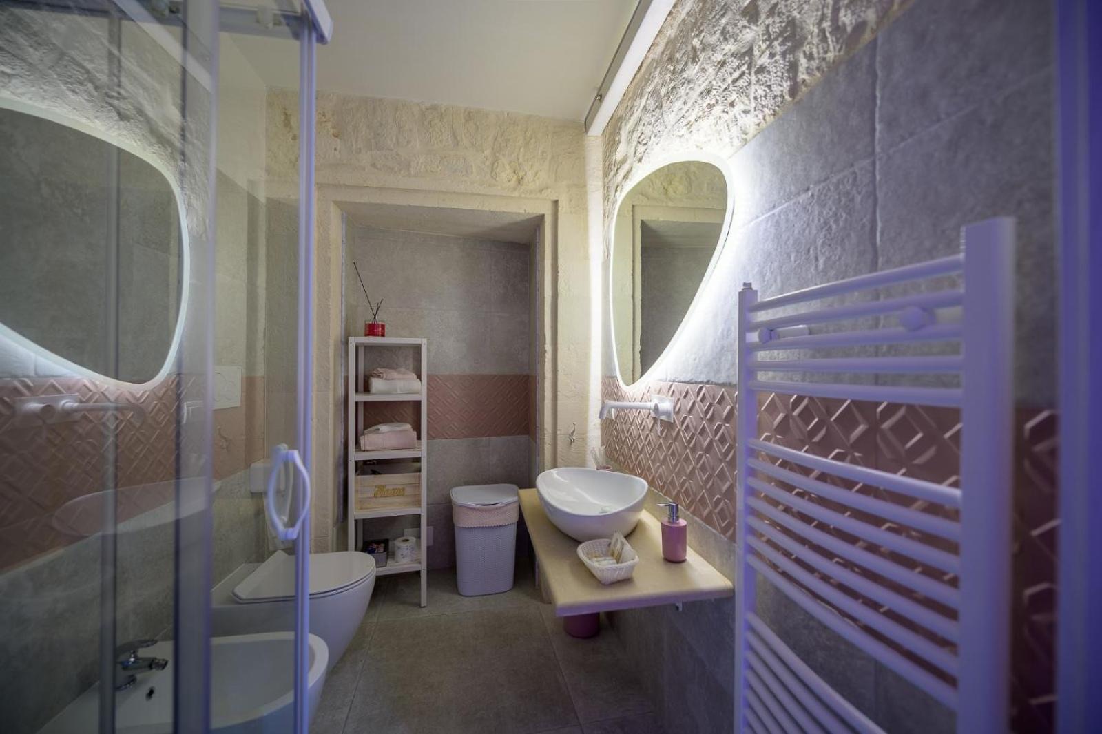 Il bagno privato di Casa Deky con doccia, doppio specchio ovale e scaldasalviette