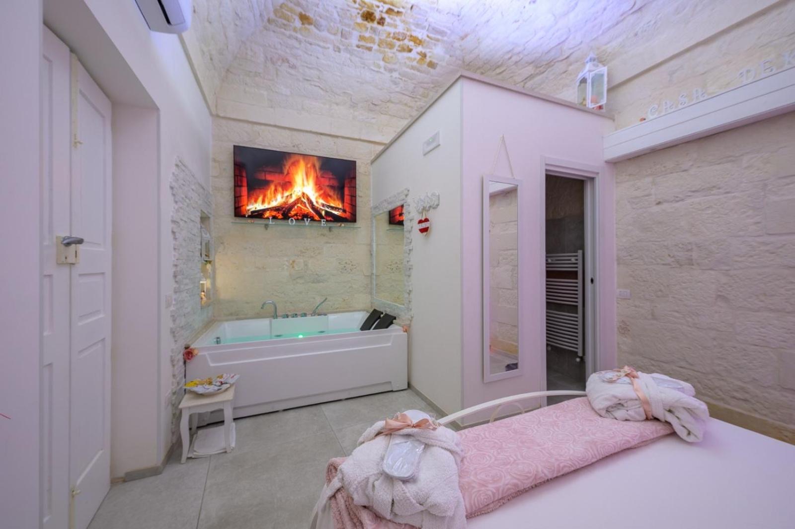 L'ambiente di Casa Deky visto d'insieme: la vasca idromassaggio accanto al letto, sotto la volta imbiancata