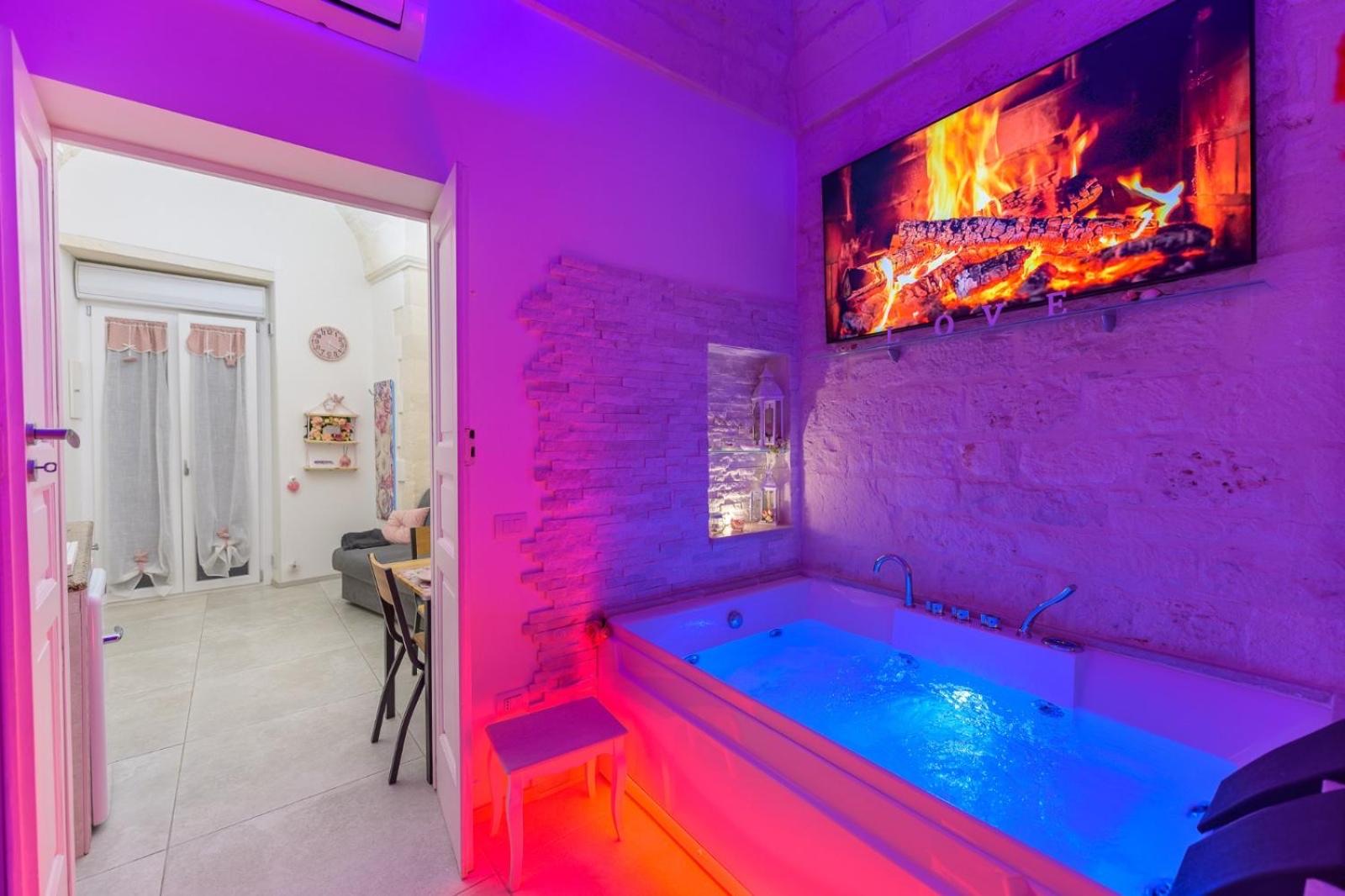 La vasca idromassaggio di Casa Deky di sera, con la cromoterapia accesa sui toni del rosa